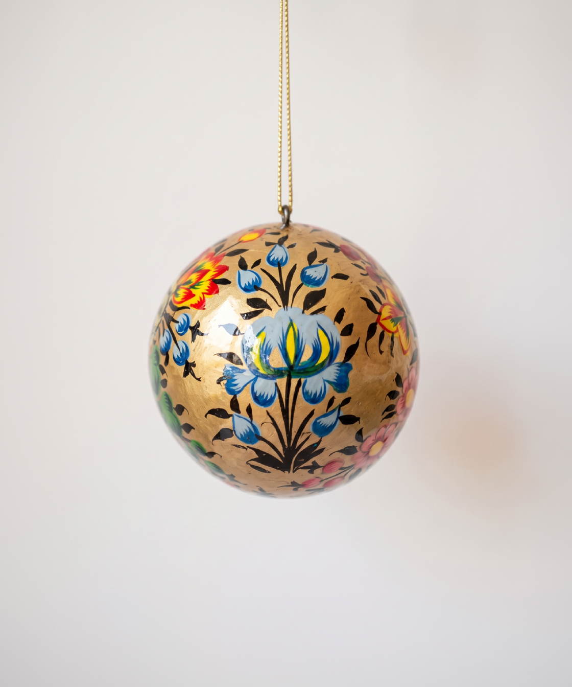 2 inch gold papier-mache Christmas ornament hand-painted with a Kashmiri floral motif