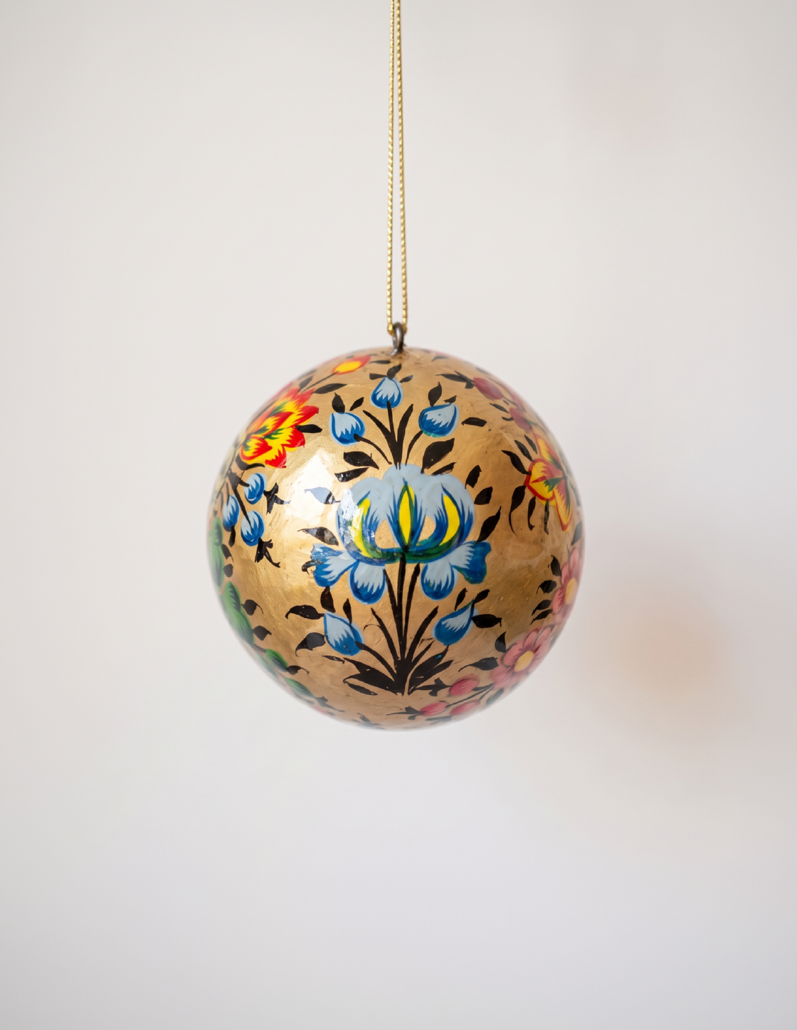 2 inch gold papier-mache Christmas ornament hand-painted with a Kashmiri floral motif