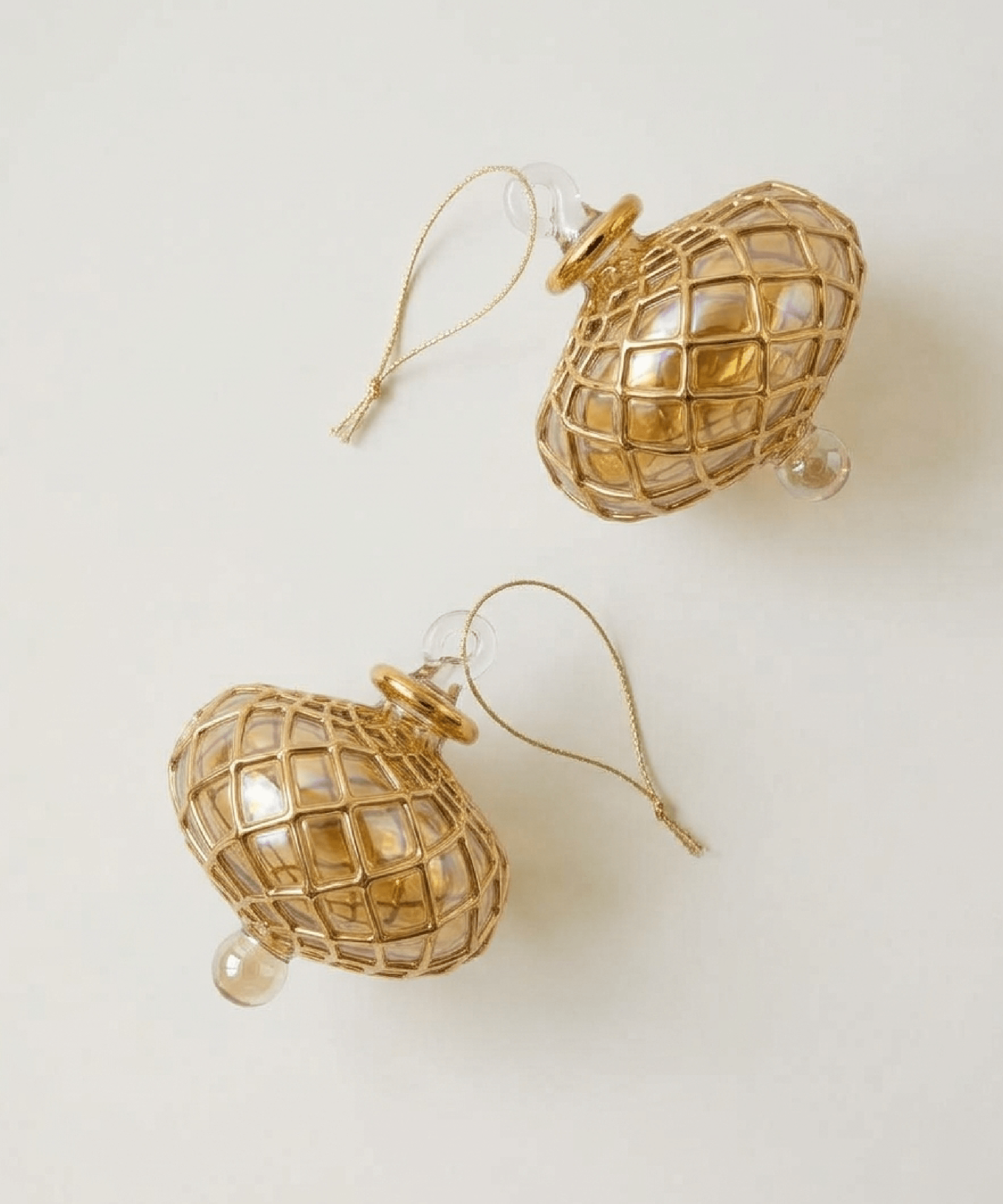 Hand-blown amber glass saucer ornament painted with a gold diamond harlequin pattern, made in Old Cairo, Egypt