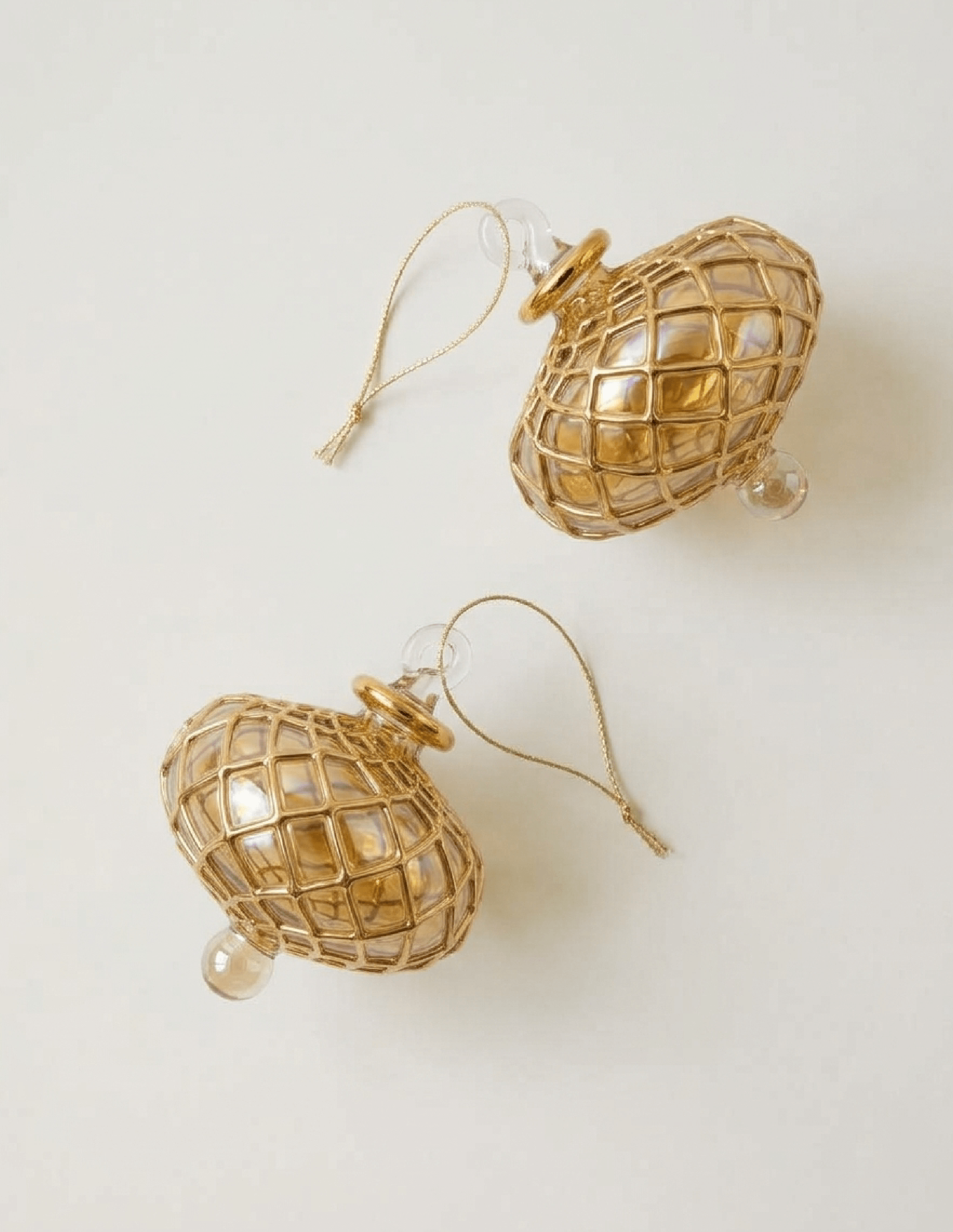 Hand-blown amber glass saucer ornament painted with a gold diamond harlequin pattern, made in Old Cairo, Egypt