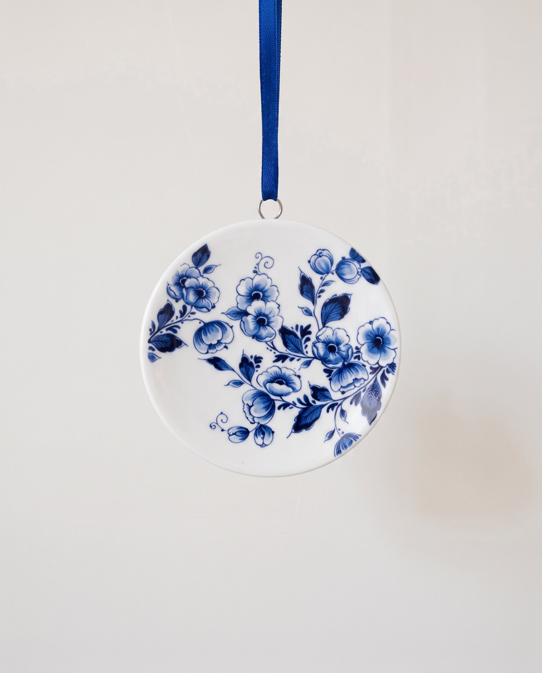 Miniature Delft porcelain plate ornament with a hand-painted blue floral centre, made in Delft, Netherlands