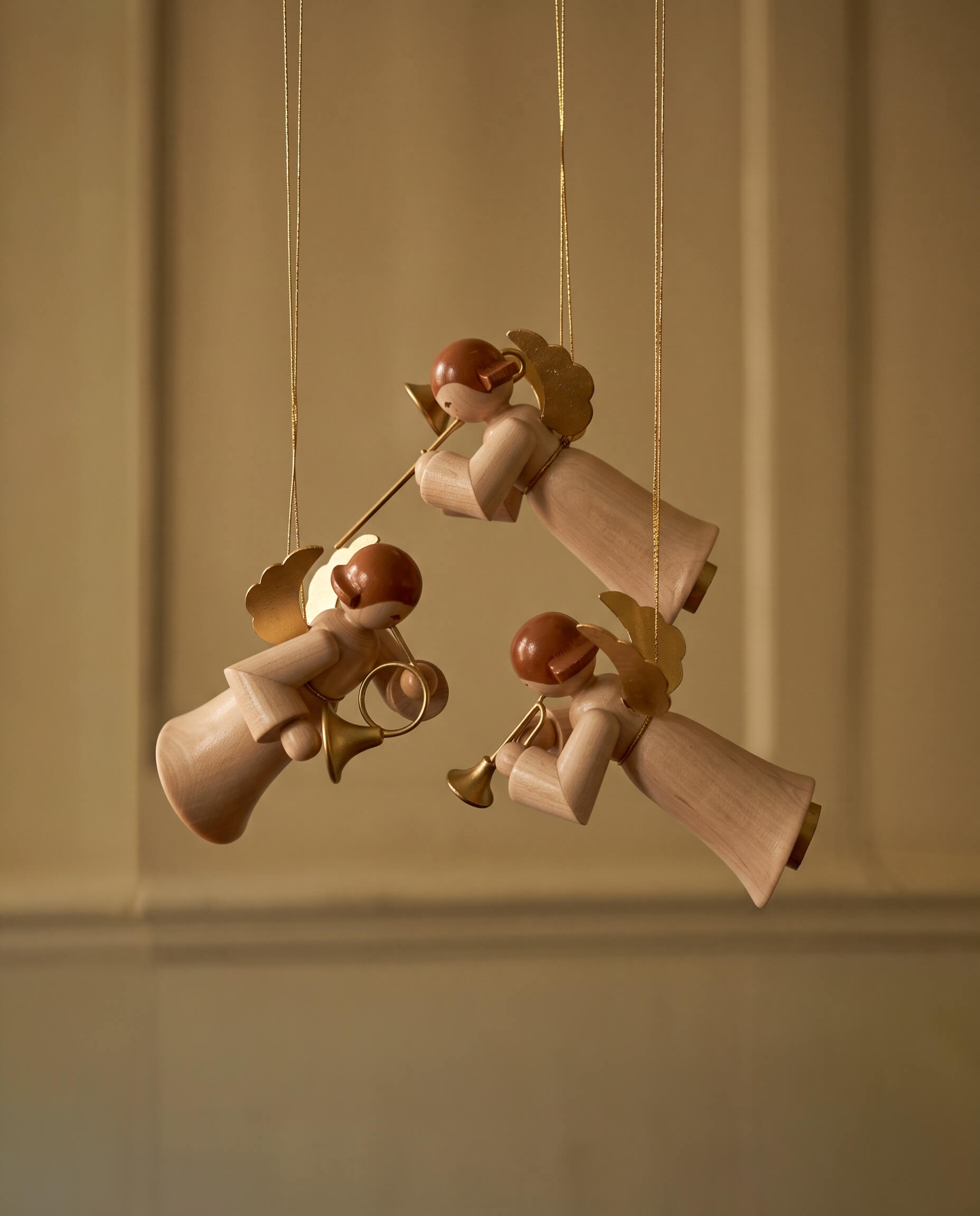 Hand-carved lime wood angel ornament holding a brass instrument, made by woodcarvers in Seiffen, Germany