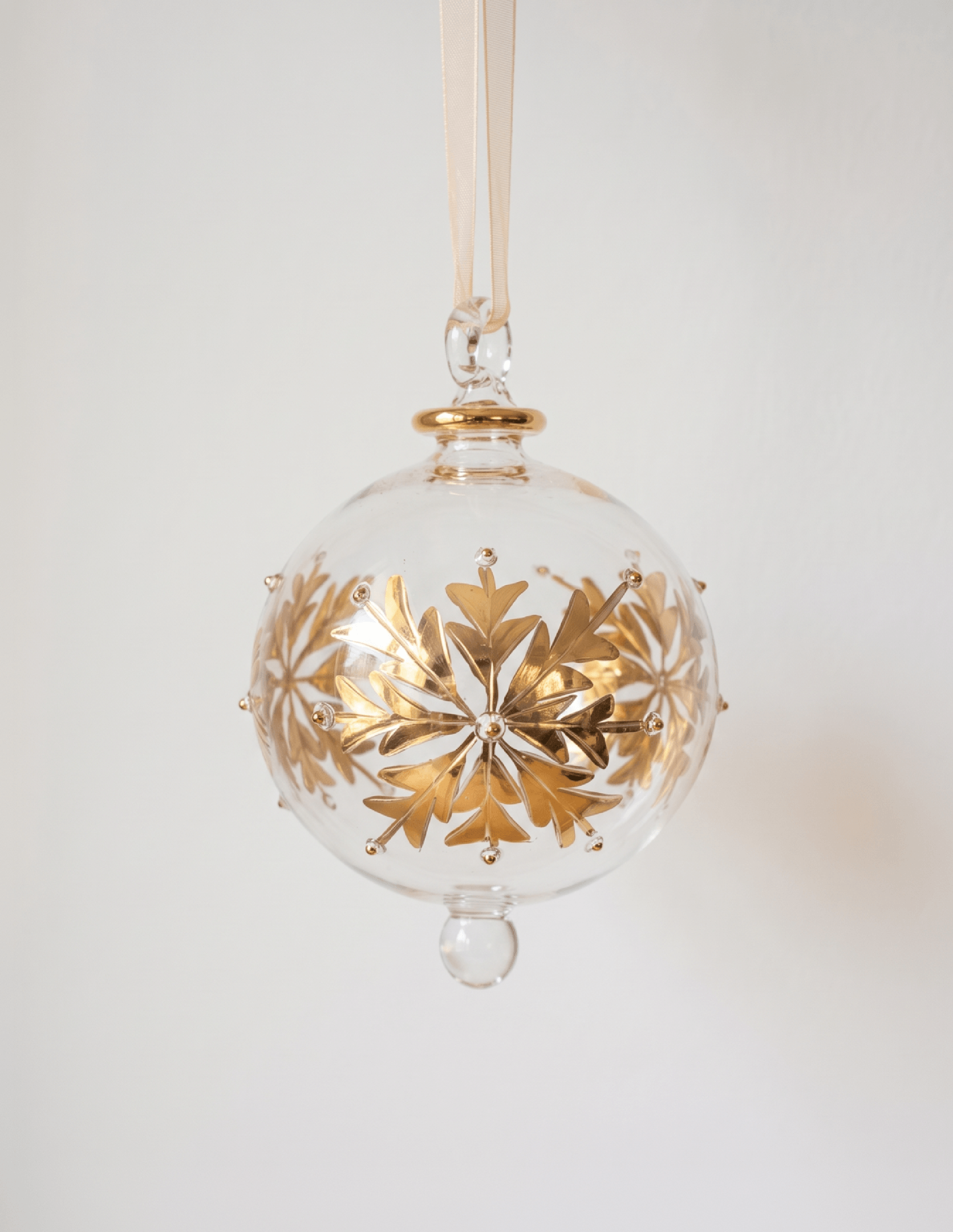 Hand-blown clear glass bauble painted with gold snowflakes, made in Old Cairo, Egypt