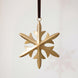 Gold hand-cut iron snowflake Christmas ornament with fine cut detail, hung from a black velvet ribbon