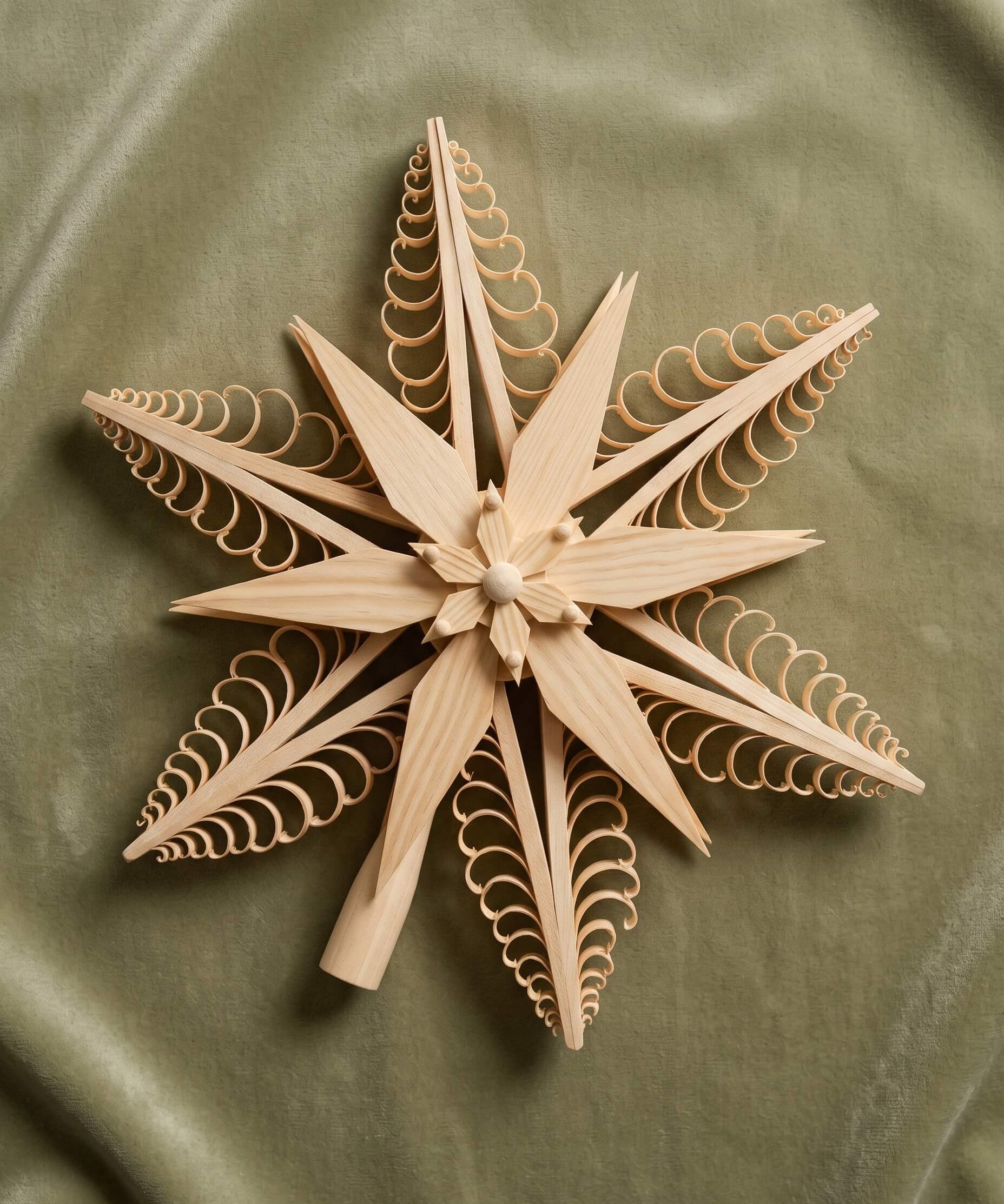 Hand-carved lime wood star tree topper with curled wood chip points, made in Seiffen, Germany