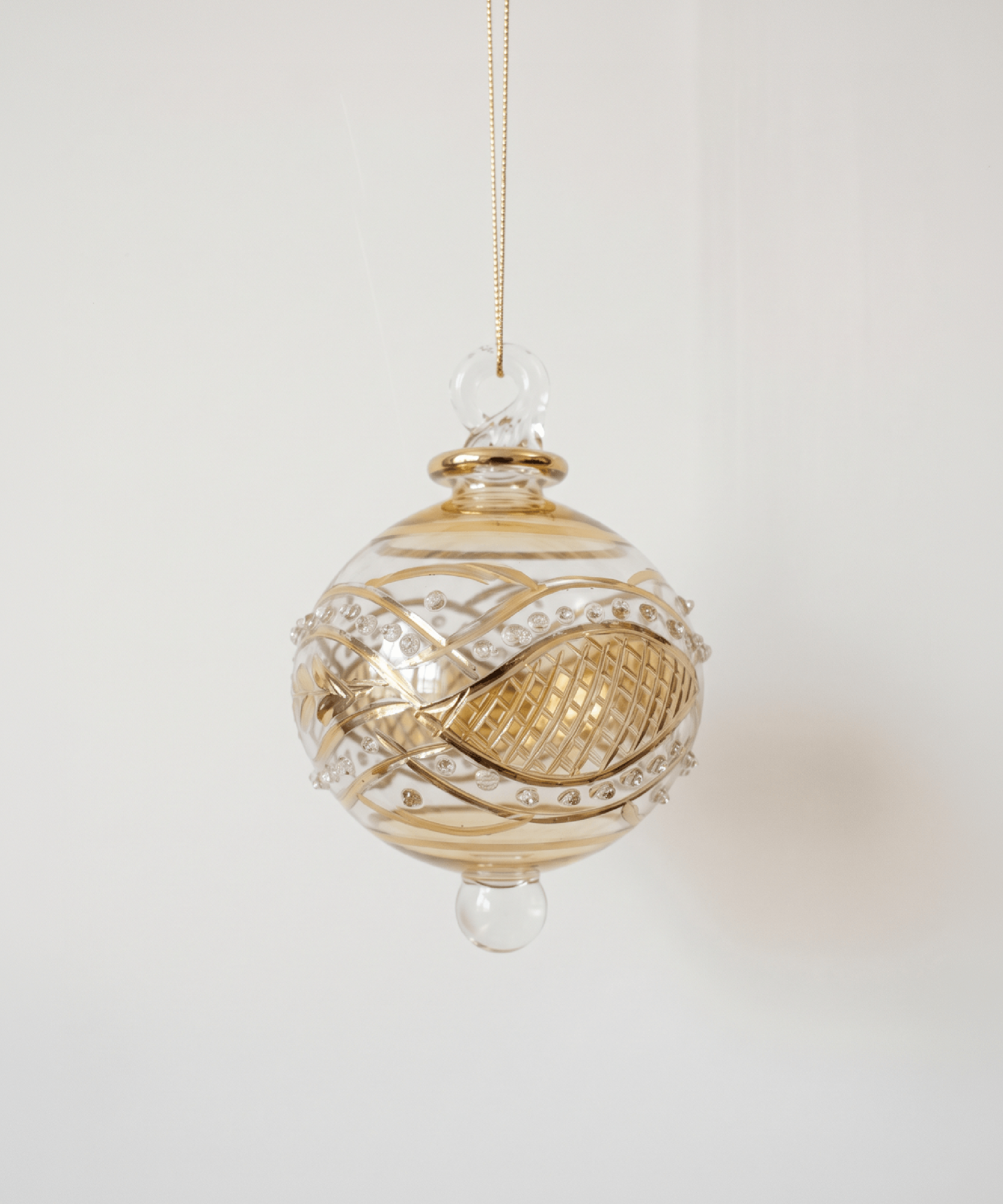 Miniature pale yellow hand-blown glass bauble with swirling gold garland pattern, made in Old Cairo, Egypt