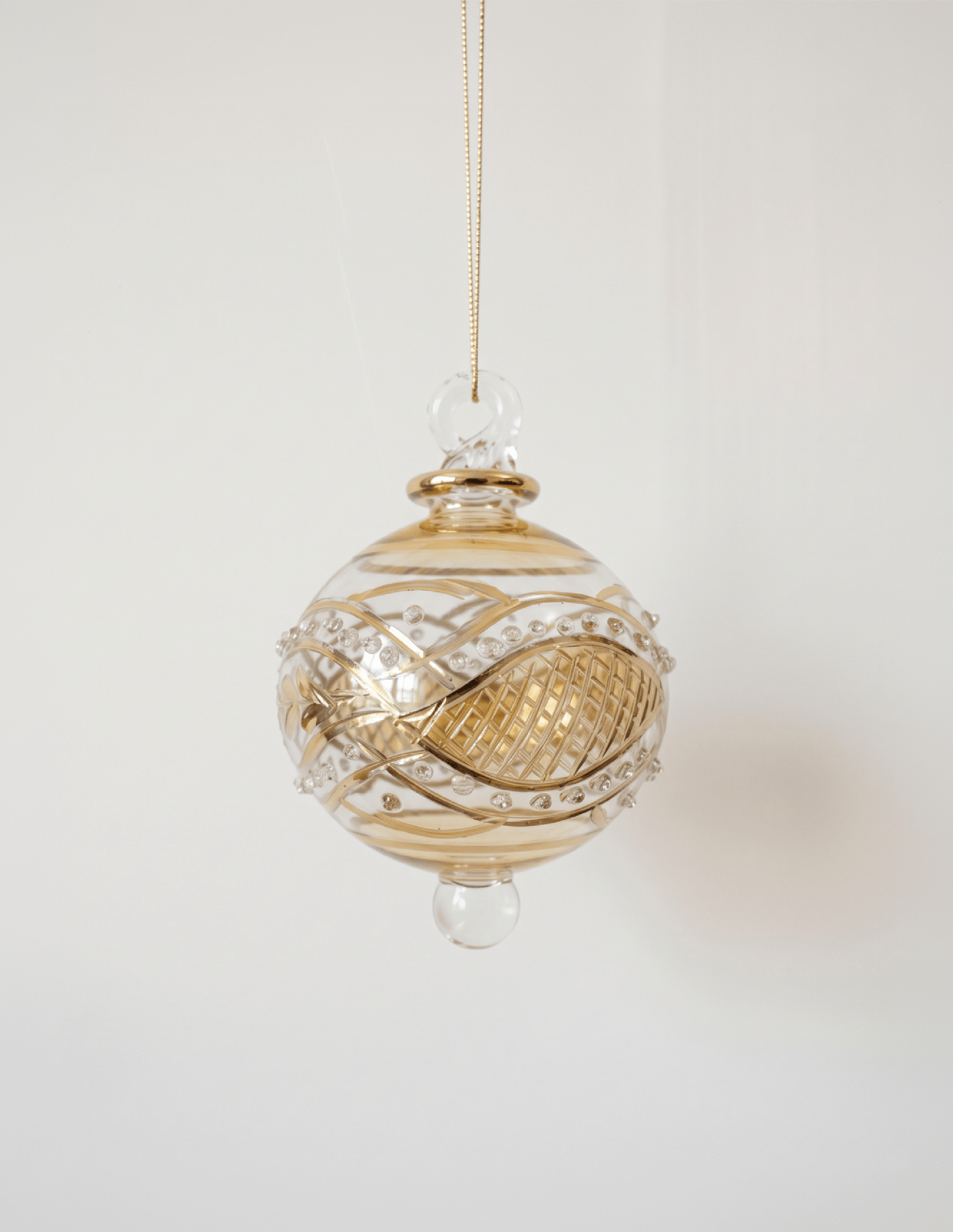 Miniature pale yellow hand-blown glass bauble with swirling gold garland pattern, made in Old Cairo, Egypt