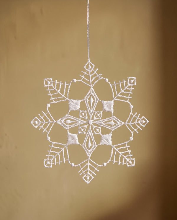 White Plauen lace six-point snowflake ornament with a diamond point design, made in Plauen, Germany