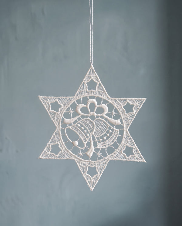 White Plauen lace star ornament with a bell design at the centre, made in Plauen, Germany
