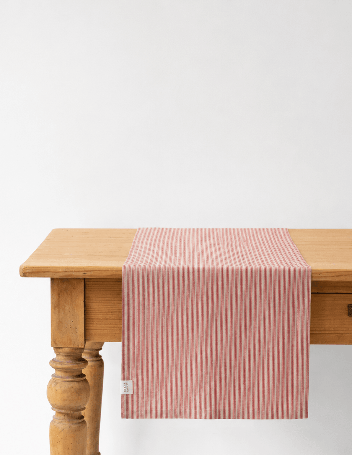 Natural linen table runner with red stripes, stone-washed and woven in Lithuania