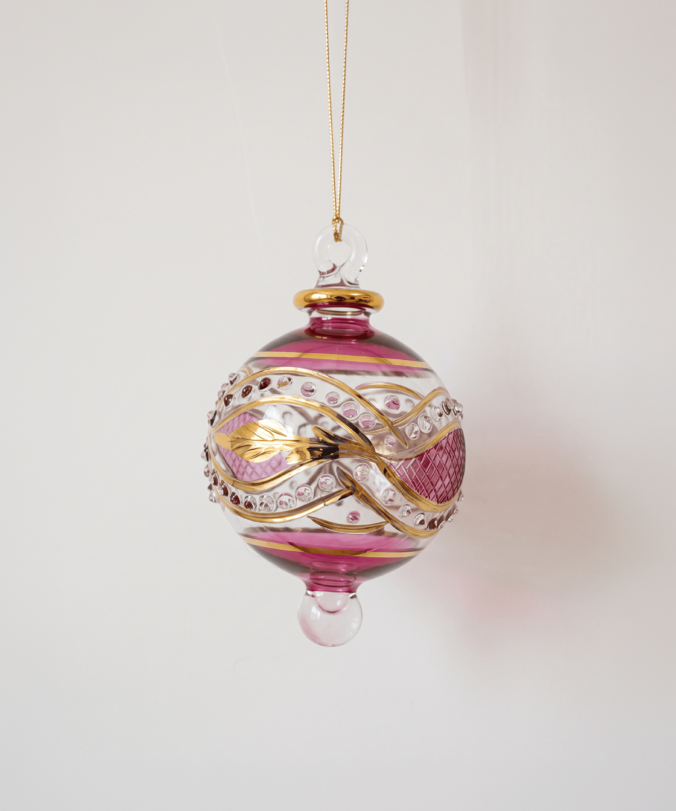 Small hand-blown ruby red glass bauble painted with gold garland swags, made in Old Cairo, Egypt