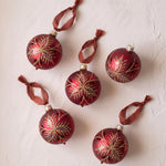 Red mouth-blown German glass bauble with glittered matte and shiny panels, made in Thuringia, Germany