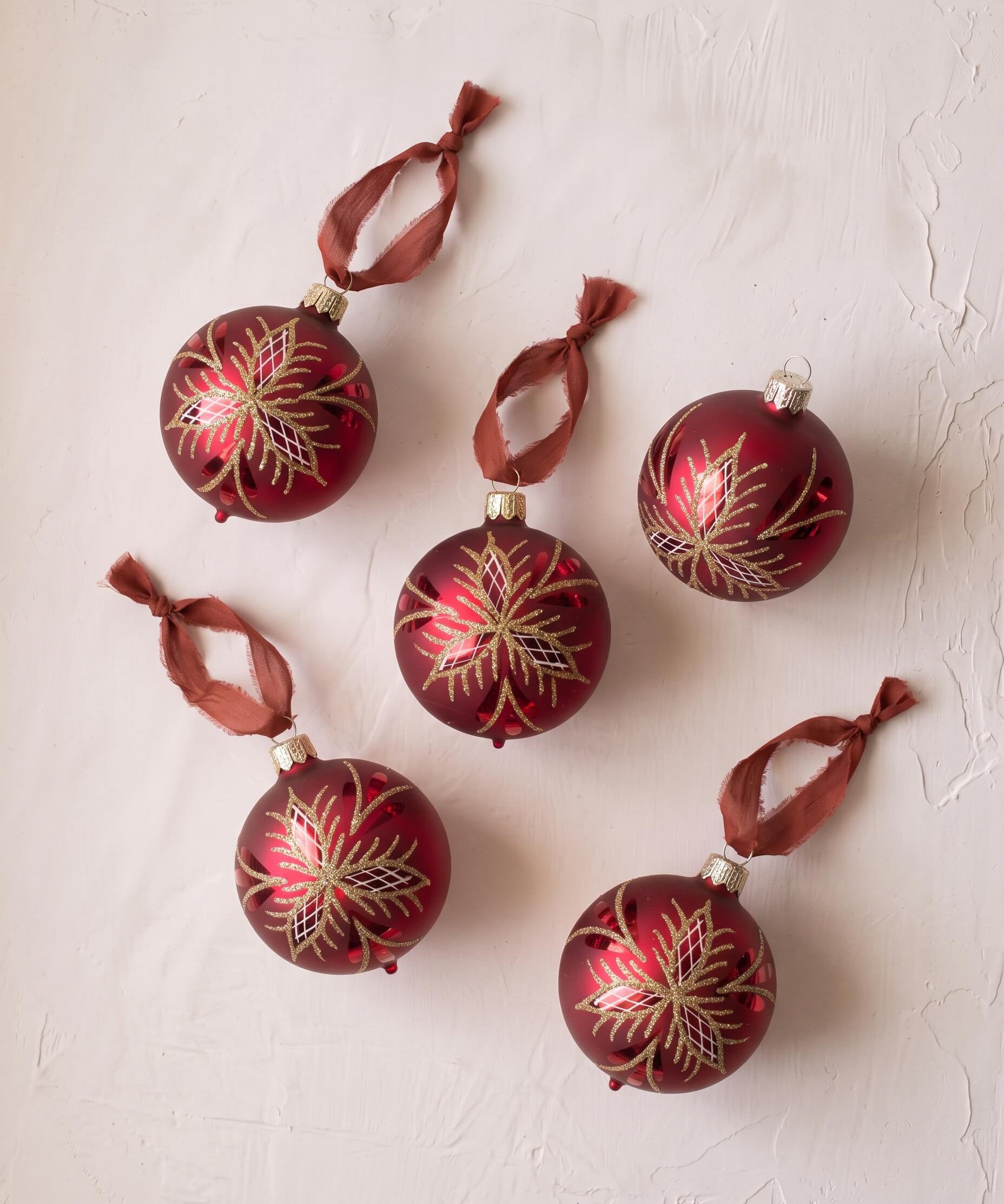 Red mouth-blown German glass bauble with glittered matte and shiny panels, made in Thuringia, Germany