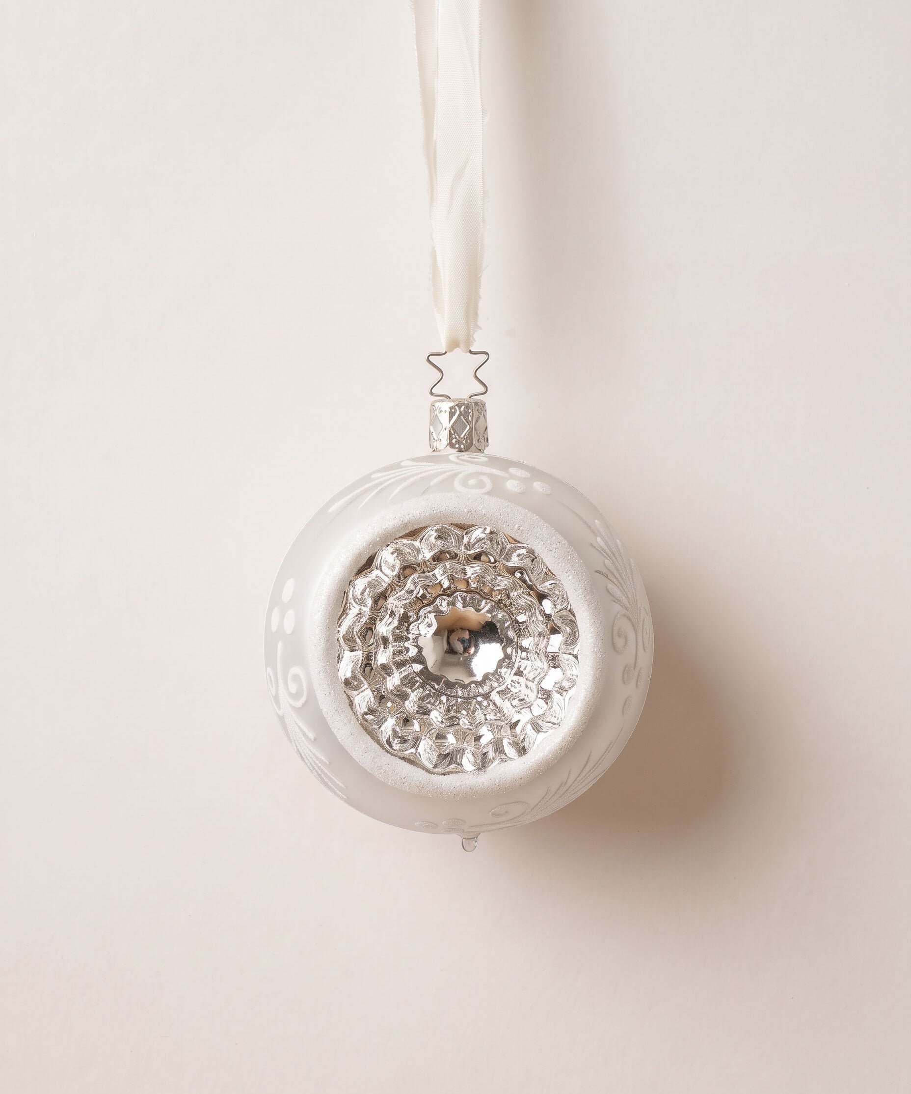 Matte white and silver glass reflector ornament with a reflective centre, mouth-blown by Inge-Glas of Germany