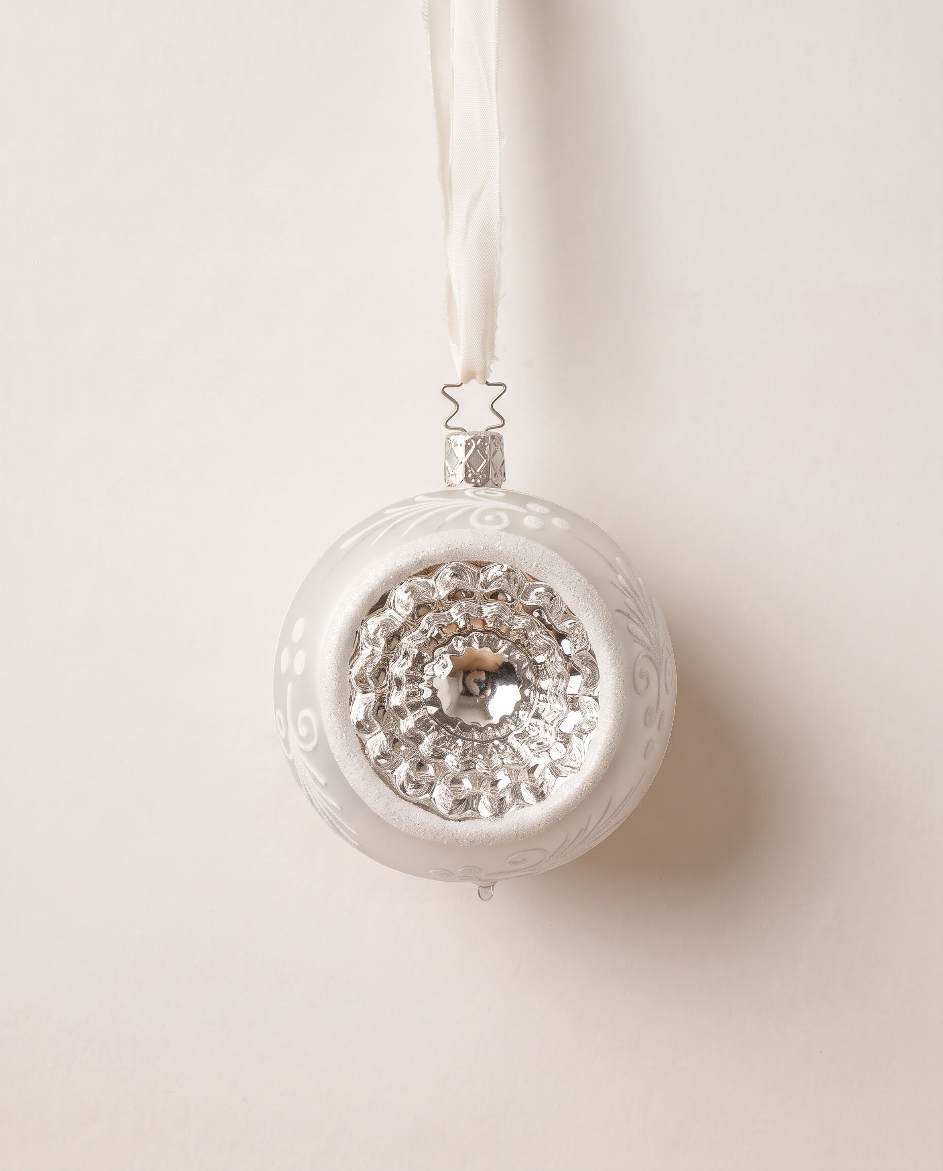 Matte white and silver glass reflector ornament with a reflective centre, mouth-blown by Inge-Glas of Germany
