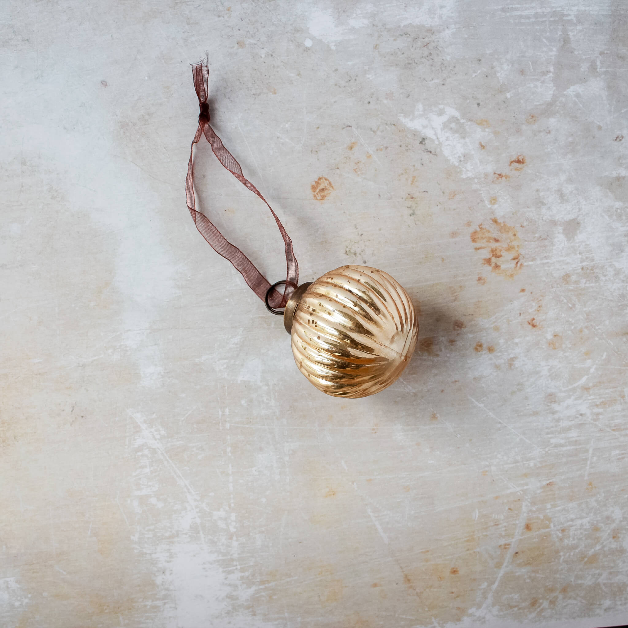 2 inch champagne gold ribbed glass Christmas bauble with a bronze cap and ribbon hanger, another view