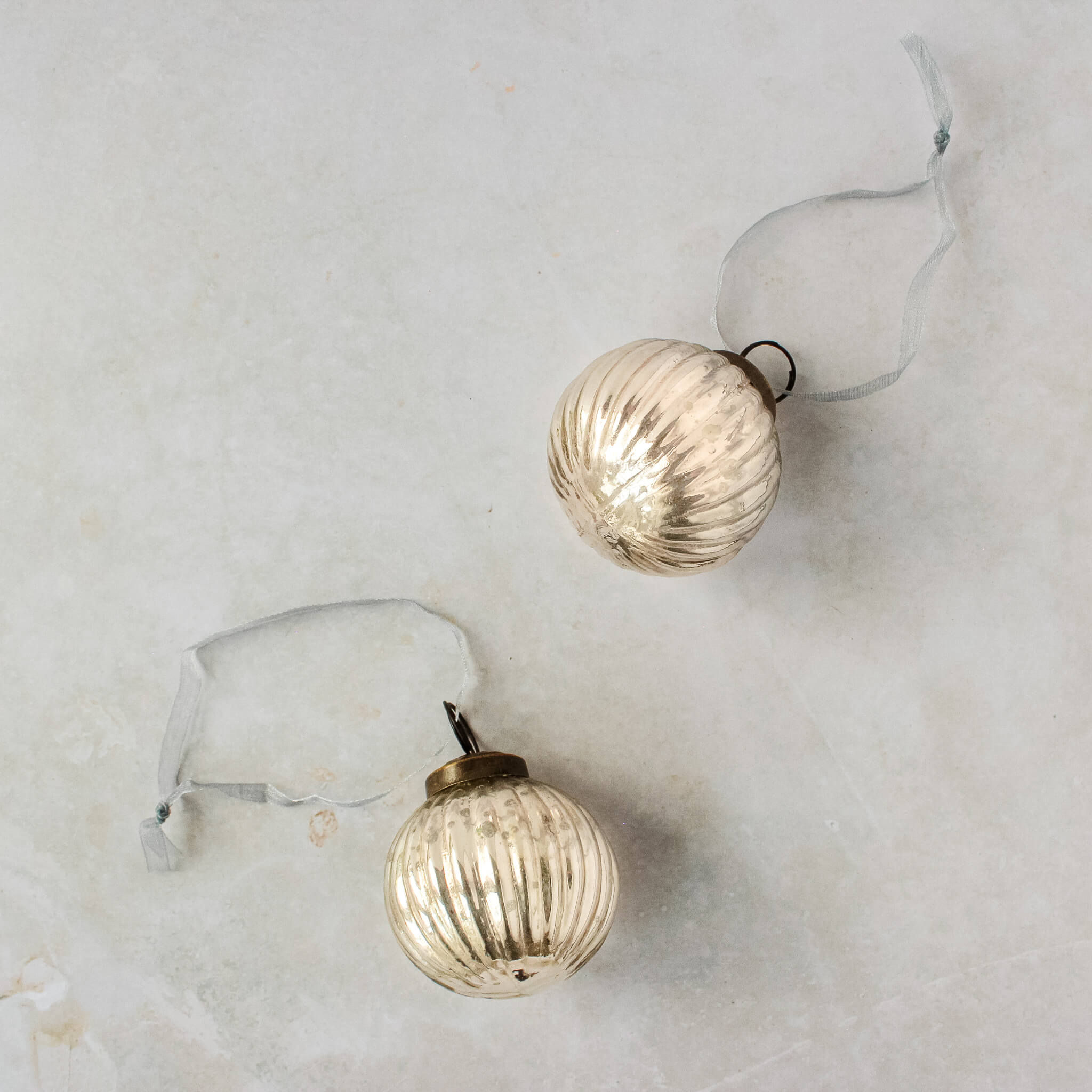 2 inch silver ribbed glass Christmas bauble with a bronze cap and ribbon hanger, another view