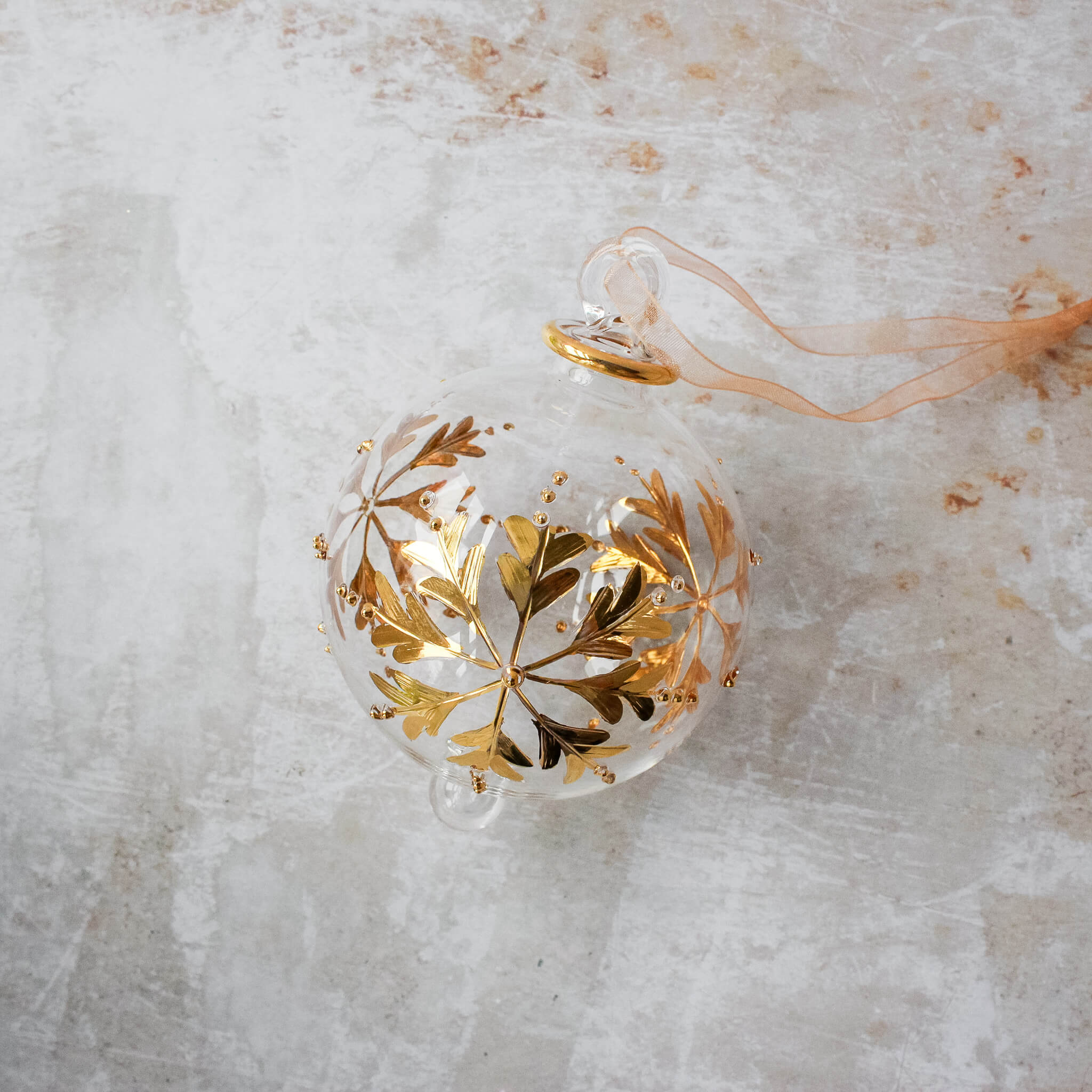 Hand-blown clear glass bauble painted with gold snowflakes, another view
